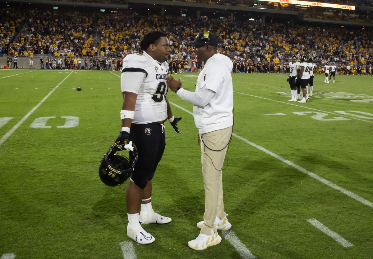 Colorado Buffaloes head coach Deion Sanders talks to defensive lineman Bishop Thomas (95) against the Arizona State Sun Devils at Mountain America Stadium